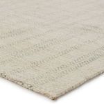 Close-up angled view showing soft low pile texture and light green stripes on light gray handwoven rug