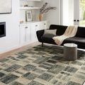 Rug styled in a modern living room with black sofa, light wood floor, and minimalist decor
