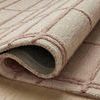 Rolled corner displaying thickness and dense wool construction of blush rug