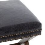Detailed view of angled legs with X-frame design crafted from dark stained wood