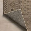 Corner fold of rug turned over displaying woven back side and finished edges