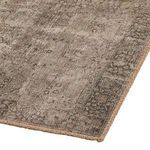 Close angle on rug edge showing pile texture and brown stitched border detail