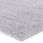 Close-up angled view showing rug’s dense looped PET yarn texture