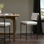 Pair of Benton Stools styled at wood bar table in room with window and dark curtain