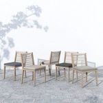 Cluster of Sherwood Brown wooden outdoor chairs with mixed-tone cushions displayed outside on paved surface