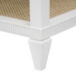 Close-up of white tapered leg and fluted apron detail over woven shelf on Sienna table base