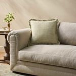 Pillow styled upright on a light beige sofa in a neutral living room setting