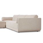 Side profile showing shapely armrest of sectional and plush cushions in cream tone