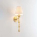 Wall-mounted Vails Gate sconce illuminated with white fabric shade against plain white wall