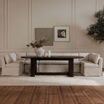 Full room view of banquette surrounding dark oval dining table on light rug