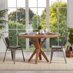 Rug under dining table with wooden top and metal chairs by large window with garden view