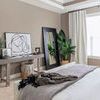 Single Black Circles IV painting leaning on a beige wall above a console table beside bedroom window with curtains