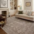 Louisa Rug displayed in a different styled living room with lighter pillows and rattan lamp.