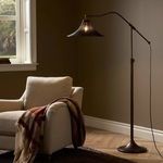 floor lamp beside beige armchair in living room with light on