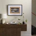 Wider view of Sun Ripples artwork hanging above wood console, next to staircase with cable railing