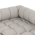 Detailed view of padded tufted seating area with buttoned fabric in light grey tone