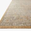 Close-up angled view highlighting outer border and texture of the Rosemarie Gold/Sand rug