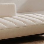 Soft natural light emphasizing the plush textured upholstery and wood leg color contrast