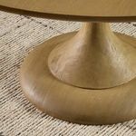 Close-up of pedestal base on textured rug to show natural oak finish and grain.