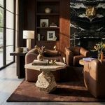 Rind Marble Table styled in a contemporary living room with leather chairs and dark wood cabinetry