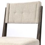 Close-up of tufted upholstered backrest with fine textured fabric and wood grain frame