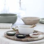 Pacifica ramekin styled on wooden tray with three small bowls and wooden spoons in soft natural light