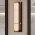 Front view of Blaine sconce with opaque white tube lit, brass accents sharp on bronze back