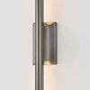 Close-up of Bernard Wall Sconce showing textured metal finish and warm light emitting from backplate edges