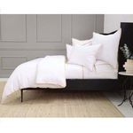 Side view of duvet set showing layering of pillows and duvet on bed with gray paneled wall background