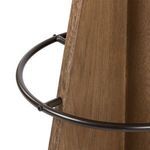 Close-up of the metal circular footrest attached to the wood base of the stool