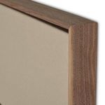 Close-up corner of walnut frame surrounding beige stretched canvas
