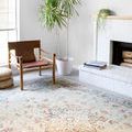 Clara Mist vintage style rug styled in a bright room with wooden chair, green potted plant, and white fireplace