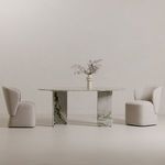 Two Larson dining chairs flanking marble dining table with decorative vase