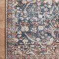 Detailed corner view emphasizing floral motifs and color contrast on Jules Denim Spice rug