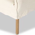 Close-up of oak leg and linen slipcover detailing on Addington dining armchair
