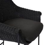 Side view focused on curved woven backrest with attached iron frame and footrest