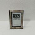 Resin Horn Picture Frame standing against white textured wall on white surface