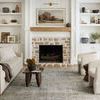 Jules Emerald rug in living room featuring beige sofa and curvy cream chairs with coffee tables