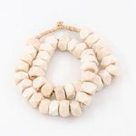 Faceted, chunky white cow bone beads strung closely together with a more geometric shape and natural ivory tones