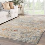 Cristobol vintage style rug styled in a bright living room with sofa, side table, and plant in background