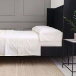 Ivory cotton sateen King-sized sheet set with ladder stitch detailing styled on a black modern bed frame