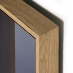Close-up of corner featuring smooth light wood grain and mitered edges of vertical grain white oak floater frame