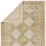 Rug partially folded to reveal the backing and thickness of the hand-knotted trellis design