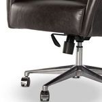 Close-up on polished metal swivel base and adjustment controls with casters