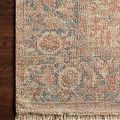 Hand-woven Priya Brick Navy rug with tonal floral and geometric pattern in navy, brick red, and cream hues with fringed edges