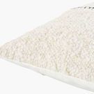 Close-up side angle highlighting chunky woven wool texture and smooth white fabric piping along the edge