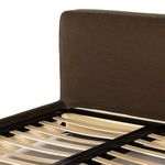 Close-up of padded headboard corner covered in coffee brown linen slipcover fabric