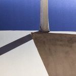 Close-up of the bottom right shadow and beam intersection with texture details on the photograph