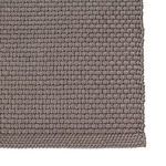 Detailed macro shot of tightly woven chunky texture and bound edge on dark gray rug