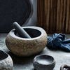 Valley Nature Bowl styled as mortar with pestle, set among other stoneware and textured kitchen textiles
